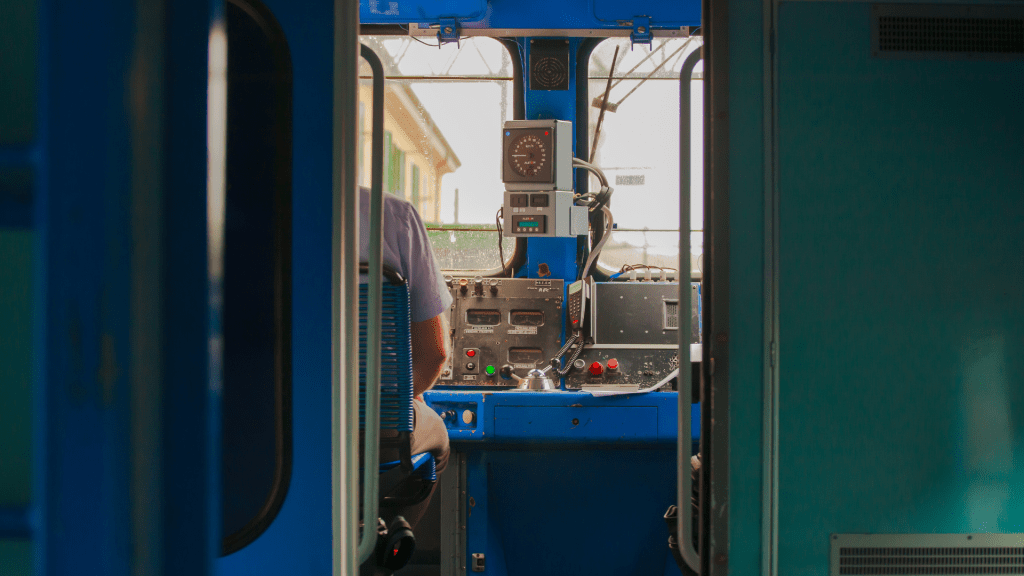 Conducteur de train de la SNCF concentré en cabine, manœuvrant un train tout en évaluant des scénarios complexes, illustrant l'application pratique des compétences testées lors des évaluations psychotechniques.