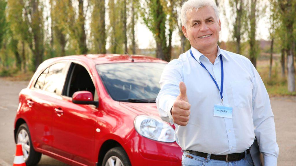 Une personne agée devant une voiture